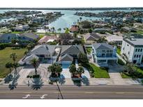 Aerial view of waterfront homes featuring lush landscaping, private docks, and beautiful water views at 2801 Gulf Blvd, Belleair Beach, FL 33786