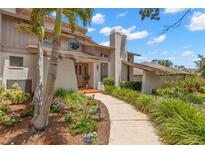 Beautiful home exterior with a well-manicured lawn, mature landscaping and a unique architectural design at 3133 Harvest Moon Dr, Palm Harbor, FL 34683
