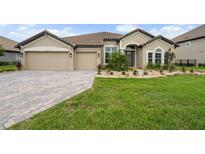 Charming single-story home with a well-manicured lawn, paver driveway and a lovely garden at 33219 Kateland Dr, Wesley Chapel, FL 33545