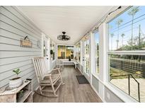 Inviting enclosed front porch with ample natural light, rocking chairs, and views of the outdoors at 504 Cleveland Ave, Largo, FL 33770