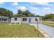 Charming single-story home with a blue front door and a well-manicured lawn at 6816 S Hesperides St, Tampa, FL 33616