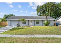 Charming single-story home featuring a well-manicured lawn, decorative ironwork, and a welcoming front entrance at 9053 Hickory Cir, Tampa, FL 33615