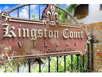 Elegant Kingston Court Villas community sign with a fleur-de-lis design against a wrought iron fence at 120 S Church Ave # 202, Tampa, FL 33609