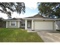Charming single-story home with a well-manicured lawn and an attached two-car garage at 1602 Taylor Lake Cir, Largo, FL 33778