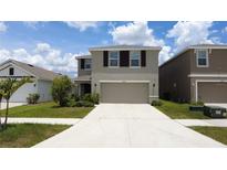 Charming two-story home with a well-manicured lawn and a spacious two-car garage at 16728 Kingman Reef St, Wimauma, FL 33598