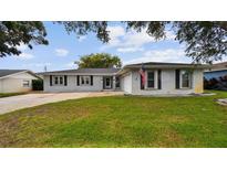 Charming one-story home with a well-maintained lawn and a classic American flag displayed at 1675 Eden Ct, Clearwater, FL 33756