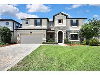 Stunning two-story home featuring stone accents, a two-car garage, and beautifully landscaped front yard at 1821 Cherry Walk Rd, Lutz, FL 33558
