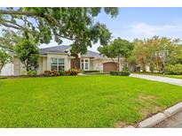 Beautifully landscaped single-story home with lush lawn, mature trees, and inviting curb appeal at 204 S Trask St, Tampa, FL 33609