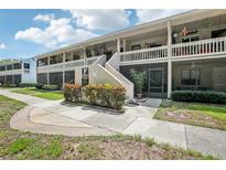 Inviting condo exterior featuring screened patios and well-maintained landscaping at 20921 Haulover Cv # 8, Lutz, FL 33558