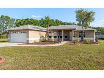 Charming single Gathering home featuring a well-maintained lawn, mature landscaping, and neutral color palette at 22755 Cypress Trail Dr, Lutz, FL 33549