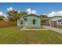 Charming light green bungalow with a cozy carport and beautiful lawn and palm trees at 2931 23Rd N St, St Petersburg, FL 33713