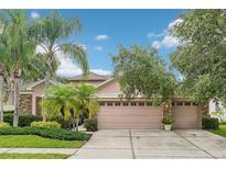 Charming home featuring a well-manicured lawn and a spacious three-car garage at 3228 Stonegate Falls Dr, Land O Lakes, FL 34638