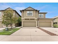 Two-story townhome featuring a two-car garage and neutral-toned exterior paint at 5153 Bay Isle Cir, Clearwater, FL 33760
