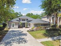 Beautifully landscaped, single-story home featuring a concrete driveway, two-car garage, and a manicured front yard at 5813 Bent Grass Dr, Valrico, FL 33596