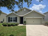 Charming single-story home with a well-maintained lawn, two car garage and manicured landscaping at 9724 Troncais Cir, Thonotosassa, FL 33592