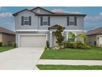 Charming two-story home featuring a well-manicured lawn, attached two-car garage, and appealing curb appeal at 11693 Lavender Loop, Spring Hill, FL 34609