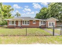 Charming single-story brick home featuring a well-maintained lawn and a classic architectural style at 1511 East Emma St. E St, Tampa, FL 33610