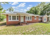 Charming single-story brick home featuring a well-maintained lawn and a classic white front door at 1511 Emma E St, Tampa, FL 33610