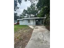 Charming single-story home with a covered parking and a quaint front yard on an overcast day at 1807 E Bougainvillea Ave, Tampa, FL 33612