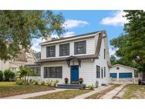 Charming two-story home boasts a blue door, gray shutters, and manicured landscaping at 310 N Lincoln Ave, Clearwater, FL 33755