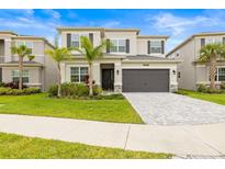 Beautiful two-story home featuring a well-manicured lawn, gray brick driveway, and a two-car garage at 3541 Great Banyan Way, Wesley Chapel, FL 33543