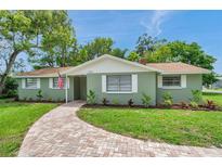 Charming single-story home with a brick walkway, manicured lawn, and fresh landscaping at 5053 18Th St, Zephyrhills, FL 33542