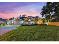 Charming single-story home with a well-manicured lawn, lush landscaping, and inviting double-door entrance at 512 Creekside Ct, Safety Harbor, FL 34695