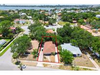 An aerial view of a charming single-story home featuring a classic red tile roof, surrounded by lush greenery in a vibrant neighborhood at 120 Bosphorous Ave, Tampa, FL 33606