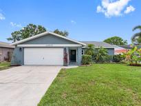 Charming single-story home with a well-maintained lawn and attached two-car garage at 12920 124Th Ave, Largo, FL 33774