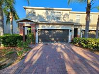 Charming townhome features a two-car garage, brick accents, and mature landscaping in a well-maintained community at 1427 Hillview Ln, Tarpon Springs, FL 34689