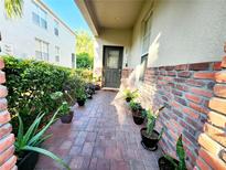 Charming front porch with brick accents, beautiful plants, and inviting entryway at 1427 Hillview Ln, Tarpon Springs, FL 34689