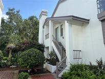 Charming two-story home with landscaped yard, staircase to the door, and lush greenery at 1712 Lake Cypress Dr # 1604, Safety Harbor, FL 34695