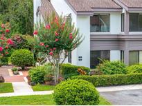 Charming townhouse exterior with lush landscaping, including a flowering tree at 1712 Lake Cypress Dr # 1604, Safety Harbor, FL 34695