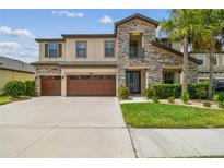 Beautiful two-story home featuring a stone facade, covered entry, and well-manicured landscaping at 21797 Briske Morning Ave, Land O Lakes, FL 34637