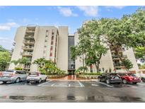 Beautiful condo building featuring lush landscaping, ample parking, and a grand entrance at 2699 Seville Blvd # 207, Clearwater, FL 33764