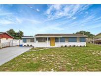 Charming single-story home featuring blue exterior, white stone accents, and a bright yellow front door at 3204 Dodge St, Tampa, FL 33605