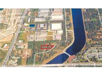 Great aerial view of the property near a waterway, with some trees and nearby shopping centers at 4210 Garden Ln, Tampa, FL 33610