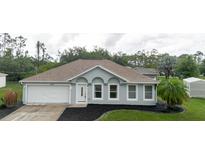 Charming single-story home with manicured landscaping, attached garage, and freshly painted exterior at 4959 Cromey Rd, North Port, FL 34288