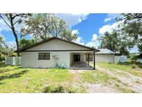 Charming single-story home featuring a covered entry, mature trees, and a well-maintained lawn at 5614 Kenny Dr, Tampa, FL 33617