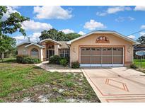 Charming single-story home with a large garage and well-maintained front yard at 6121 Piedmont Dr, Spring Hill, FL 34606
