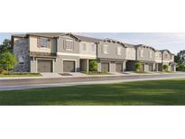 Row of townhomes showcasing neutral exteriors, attached garages, and landscaped lawns at 10186 Trumpet Honeysuckle Way, San Antonio, FL 33576