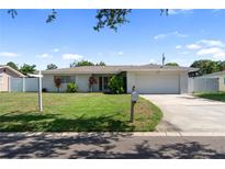 Charming single-story home with a well-maintained lawn, mature landscaping, and a two-car garage at 13898 Jamaica Dr, Seminole, FL 33776