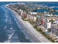 Beautiful aerial view of the oceanfront condo building with a long sandy beach and clear blue water at 15000 Gulf Blvd # 407, Madeira Beach, FL 33708