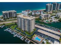 Stunning aerial view of a beachfront condominium with a private marina, pool, and beautiful coastal scenery at 1621 Gulf Blvd # 407, Clearwater Beach, FL 33767