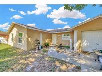 Quaint single-story home featuring a tidy front yard and neutral stucco exterior under a bright blue sky at 306 Brandywine Dr, Valrico, FL 33594