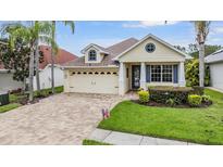 Charming single-Gathering home features a well-maintained lawn, brick driveway, and attached two-car garage at 4400 English Turn Way, Wesley Chapel, FL 33543