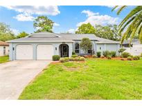 Charming single-story home featuring a well-manicured lawn, arched windows and an attached two-car garage at 4419 Gaston St, Spring Hill, FL 34607