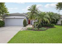 Charming single-story home with a well-manicured lawn and lush landscaping at 4926 Pennecott Way, Wesley Chapel, FL 33544