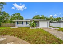 Charming single-story home with a well-manicured lawn, attached garage, and blue shutters at 538 Bamboo Ln, Clearwater, FL 33764