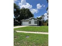 Charming single-story home featuring a well-maintained lawn and a two-car garage at 6905 Summer Harbor Ln, Riverview, FL 33578